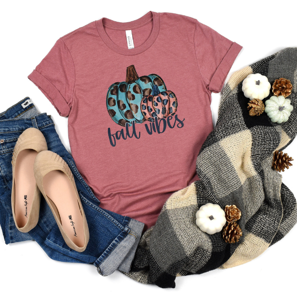 Fall themed clothing and accessories, including a pink t-shirt with a pumpkin design.